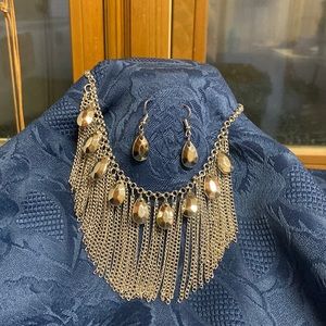 This is silver tone statement necklace with matching earrings.